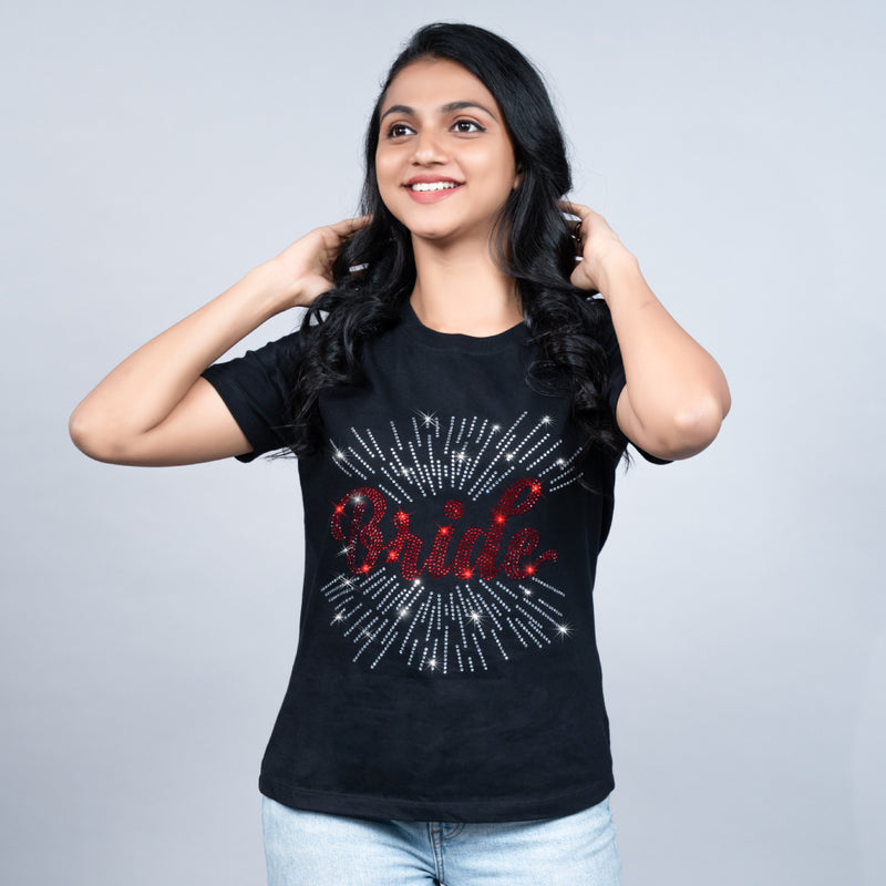 Woman wearing black “Bride” tee styled with sleek trousers—casual-glam bridal energy