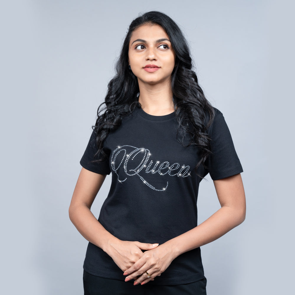 Woman wearing black “Queen” tee with glitter lettering—powerful, chic mood