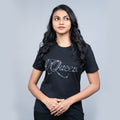 Woman wearing black “Queen” tee with glitter lettering—powerful, chic mood