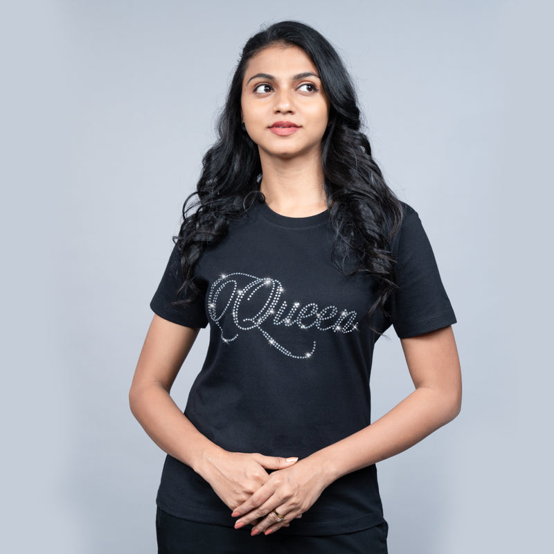 Woman wearing black “Queen” tee with glitter lettering—powerful, chic mood
