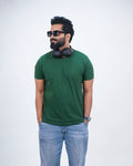 Man wearing a bottle green round neck tee with jeans—casual confidence for men in India