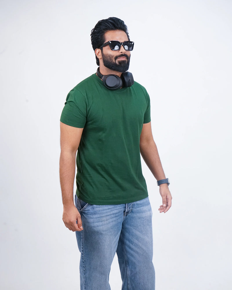 Man walking in bottle green round neck tee—chill, sharp style meets everyday motion