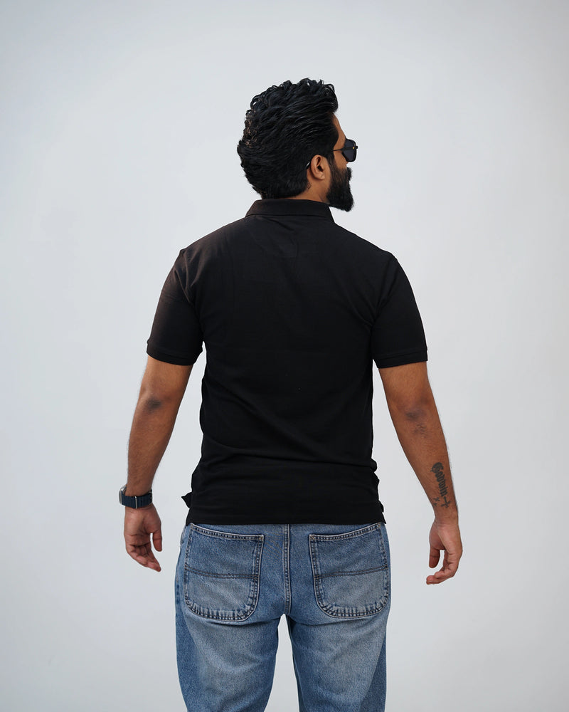 Back view of black polo tee showcasing clean silhouette and understated style