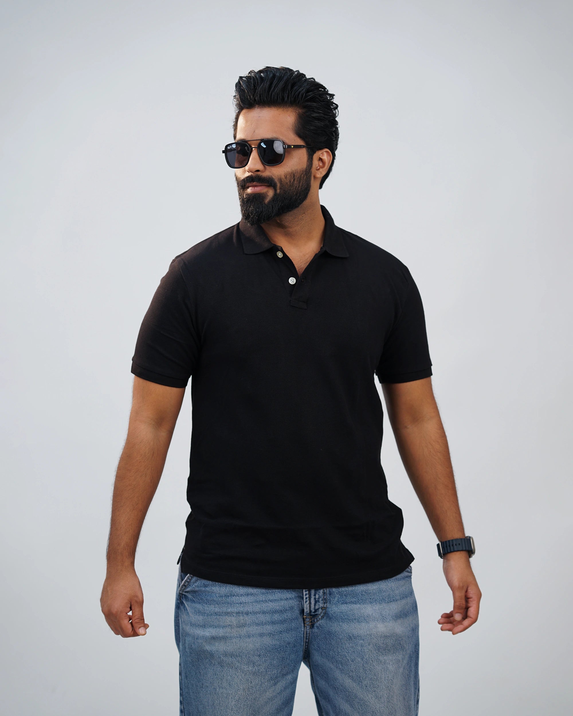 Man wearing classic black polo tee paired with chinos—simple elegance meets modern flair