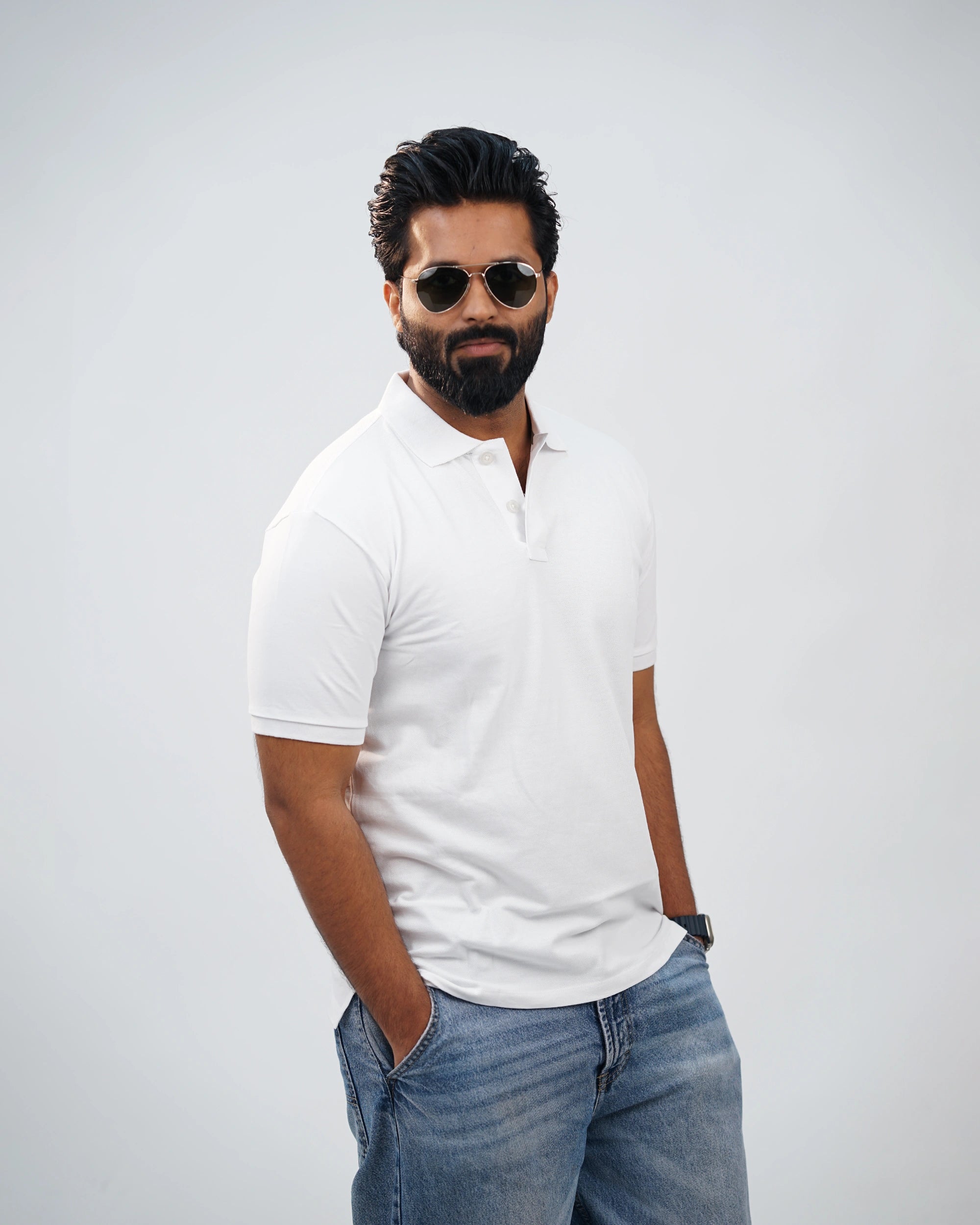 Side-angle view of white polo tee showing relaxed fit and smooth cotton