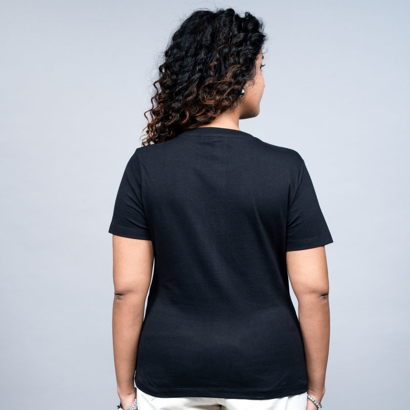 Woman wearing Heart Butterfly tee styled with white pants in relaxed mood