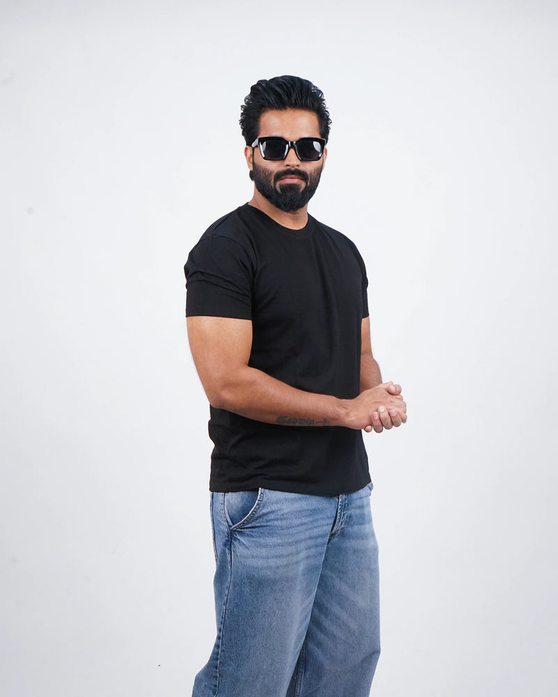 Man wearing a jet black round-neck tee for men in India — front view, minimalist fit