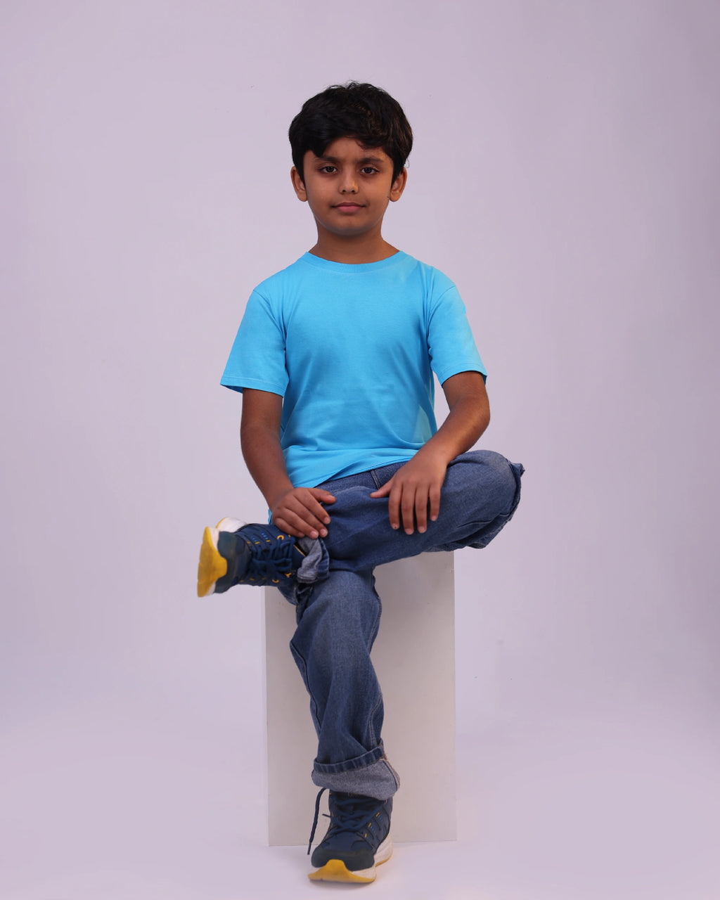 Child wearing sky-blue plain tee—casual comfort & playful mood