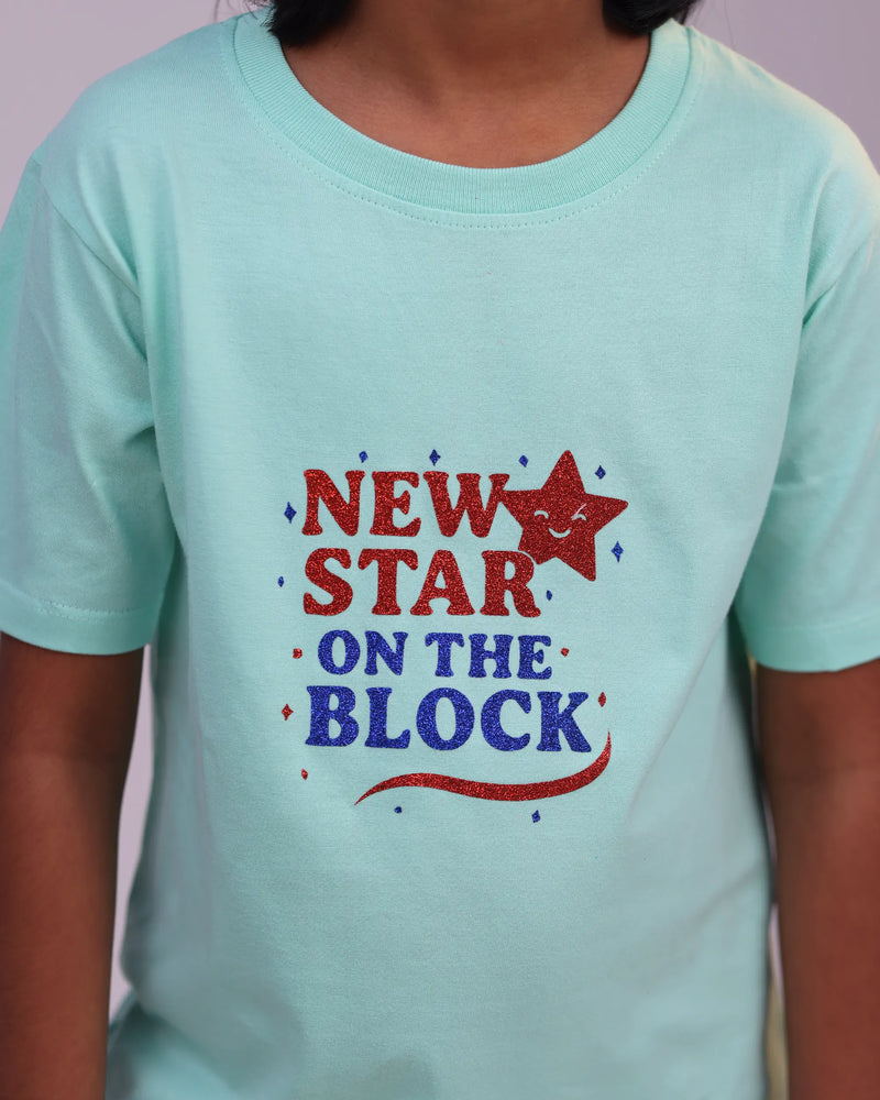 Kid wearing “New Star” tee joyfully—mint mood meets youthful confidence