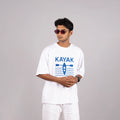 Man wearing the white “Kayak” tee styled with casual shorts—bold design meets laid-back ease