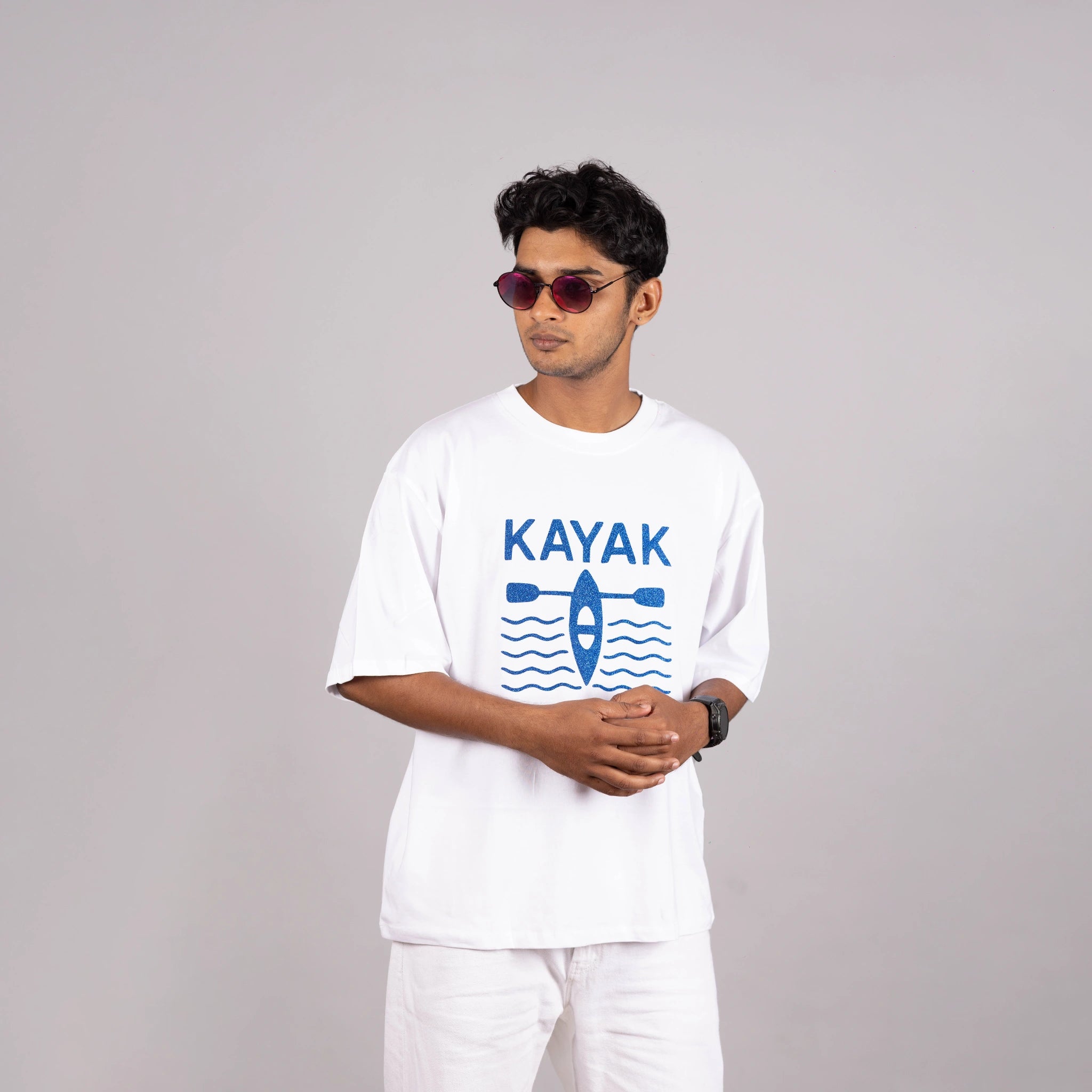 Man wearing the white “Kayak” tee styled with casual shorts—bold design meets laid-back ease