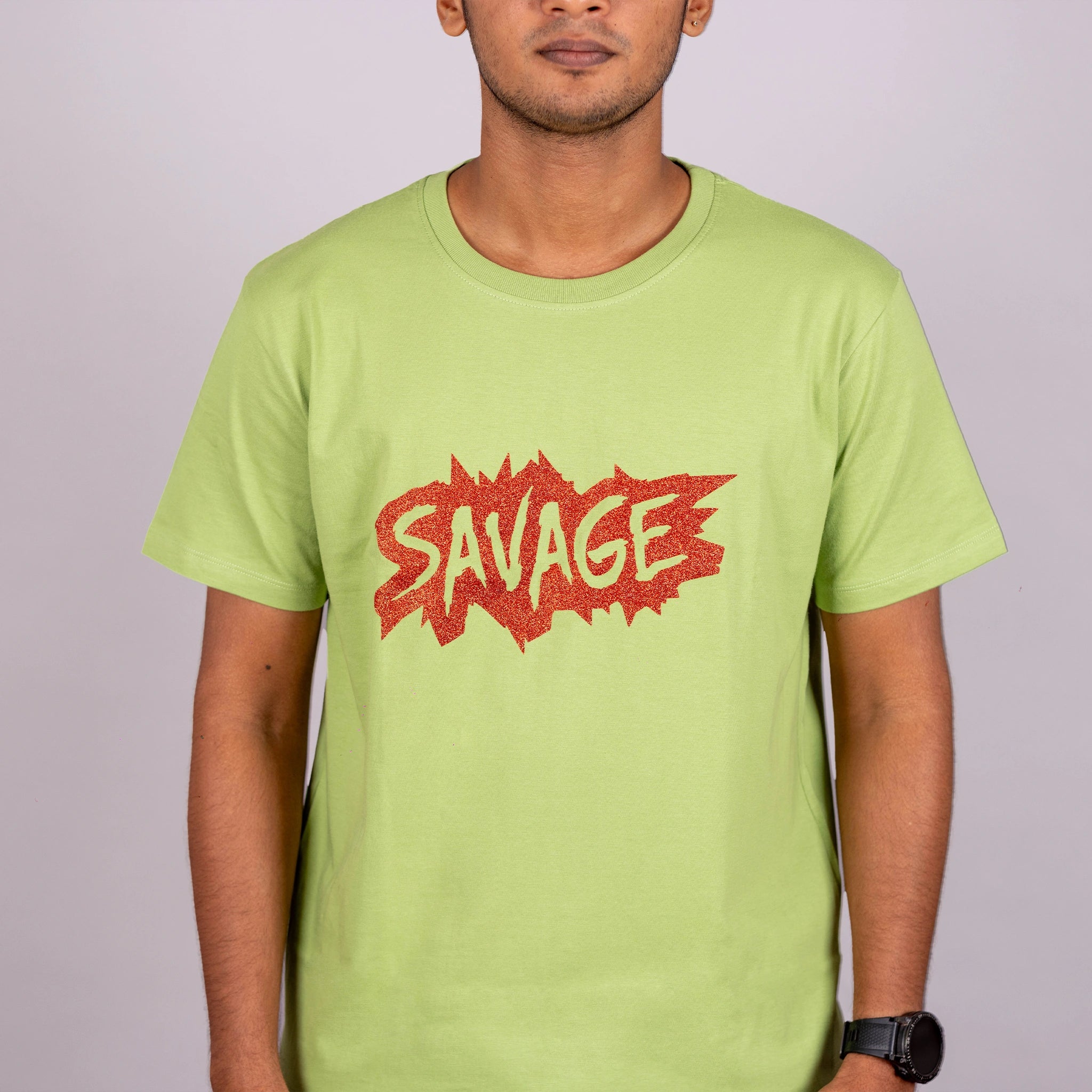 Close-up of glitter “Savage” text on kiwi green tee—eye-catching detail on soft cotton
