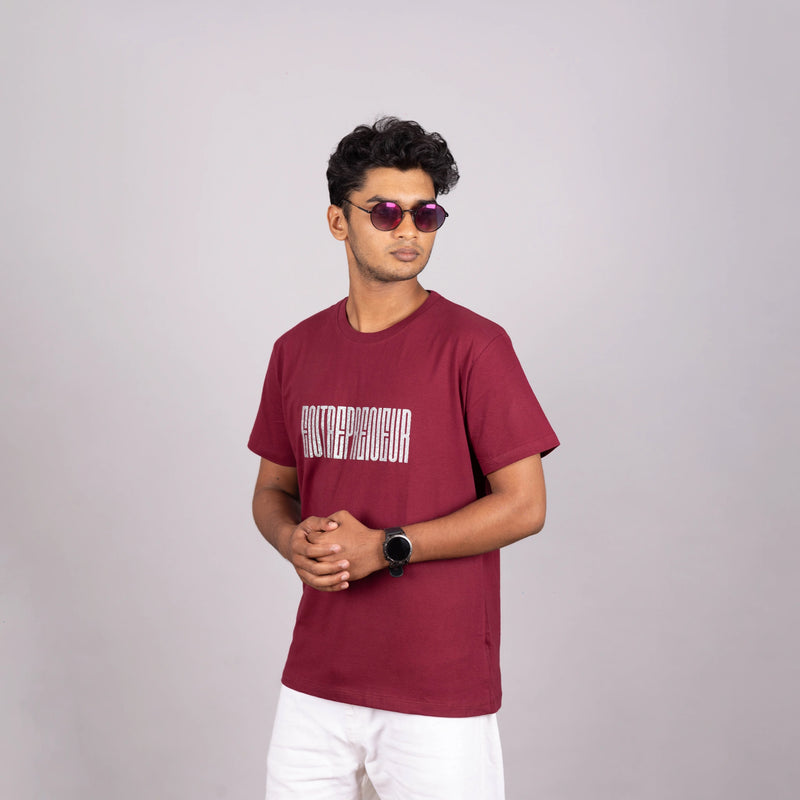 Man walking in maroon “Entrepreneur” tee—urban ease and expressive style in motion