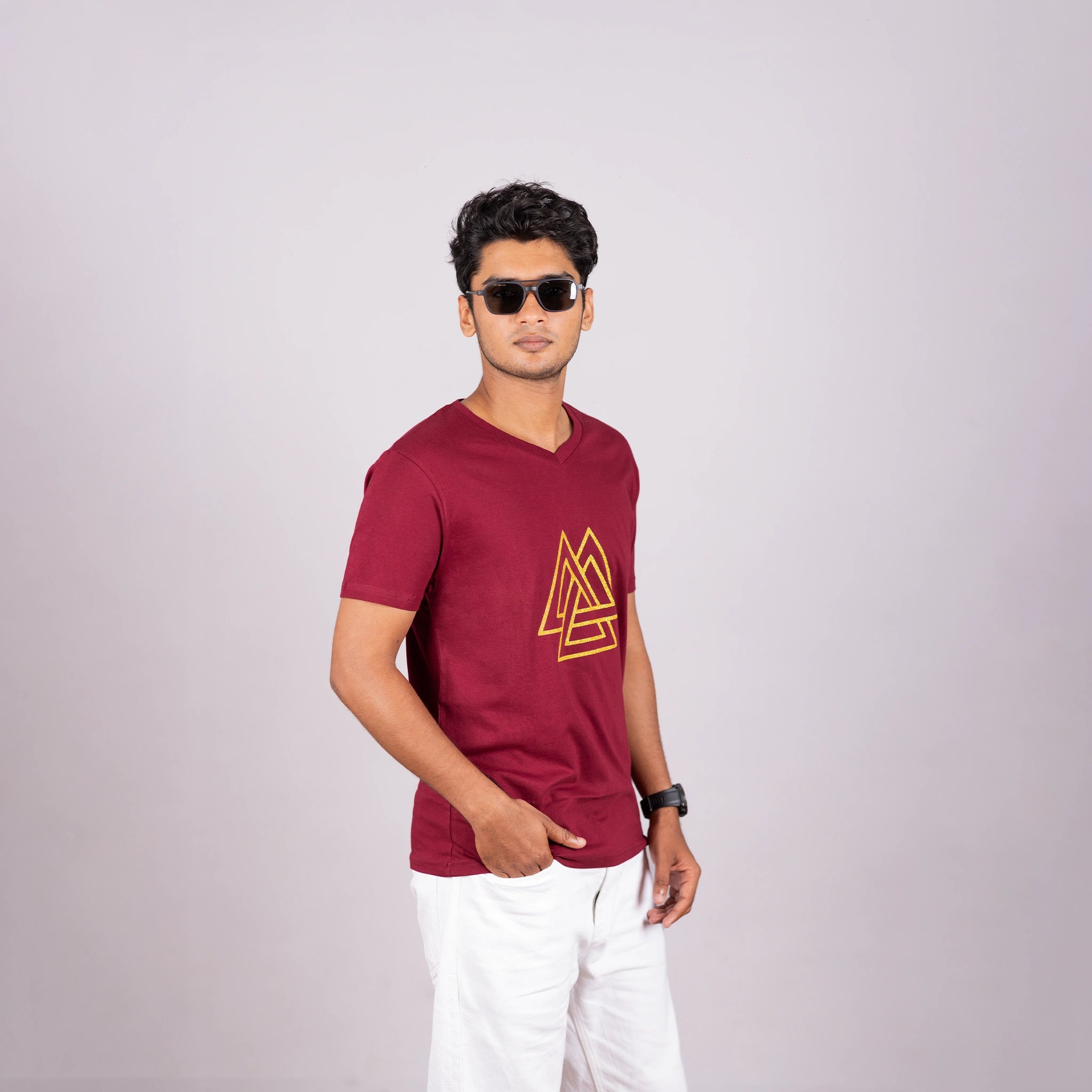 Man wearing maroon tee with gold triangle print—sharp, modern edge in everyday style