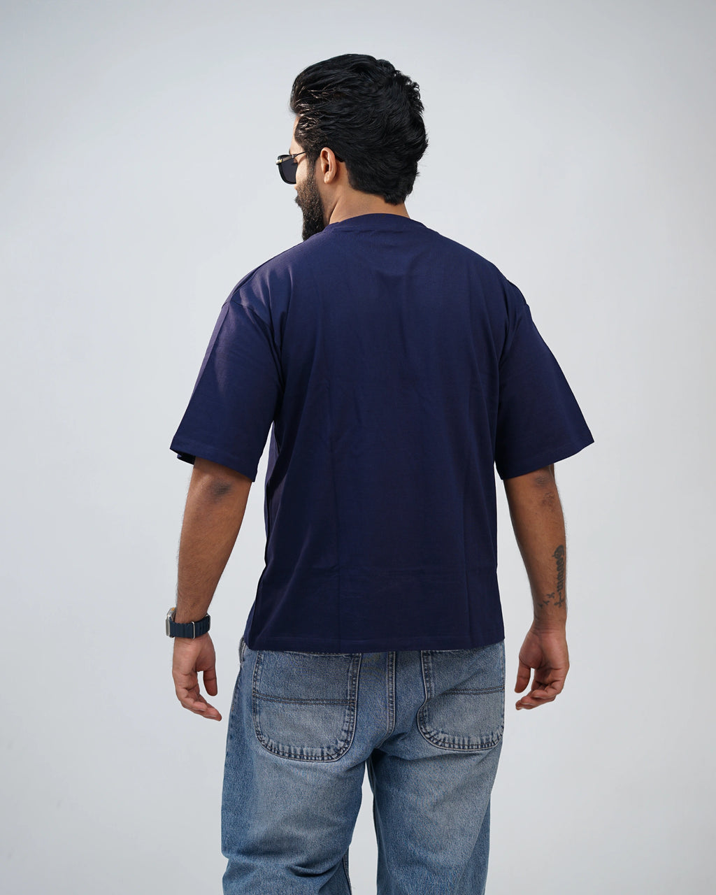 Back view of navy blue oversized tee showing clean silhouette and premium finish