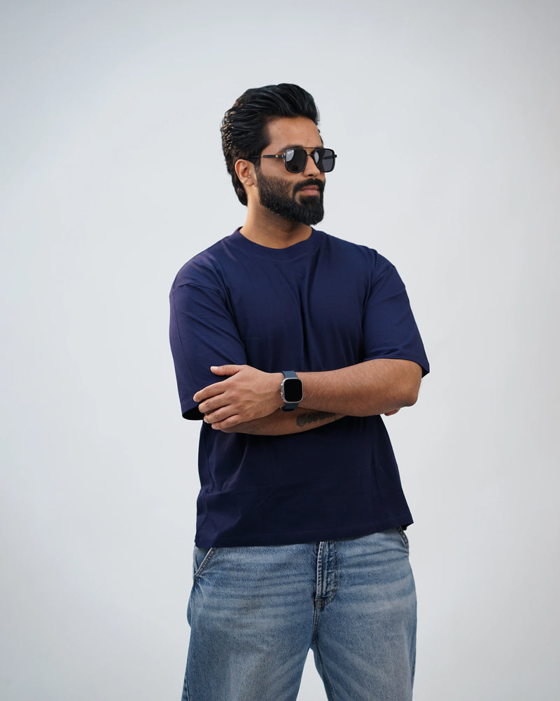 Side-angle of navy blue oversized tee highlighting dropped shoulders and relaxed fit