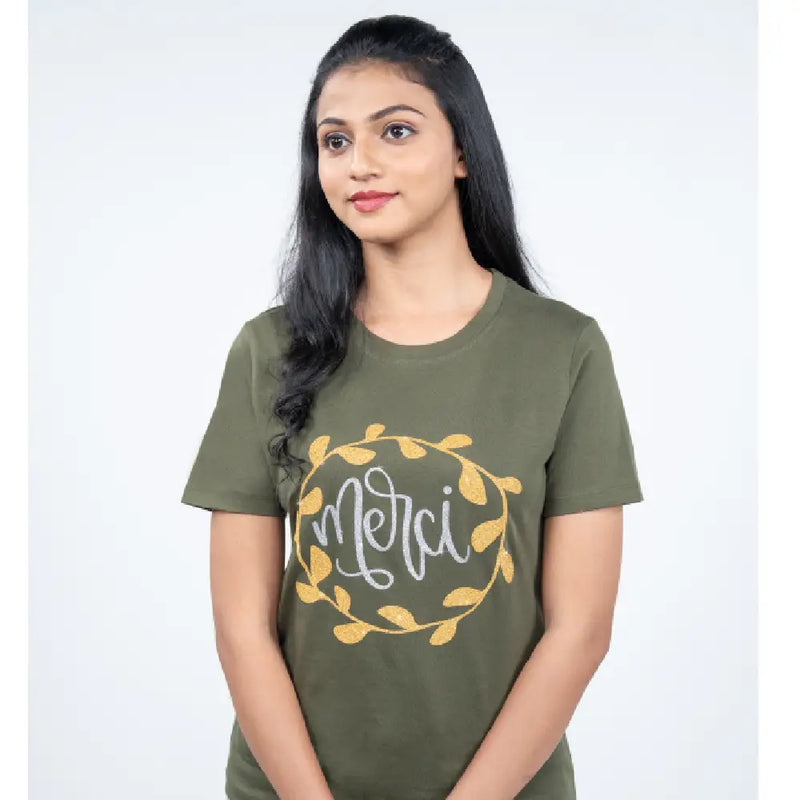 Side angle view of olive-green “Merci” tee showing soft fit and rhinestone “Merci” detail
