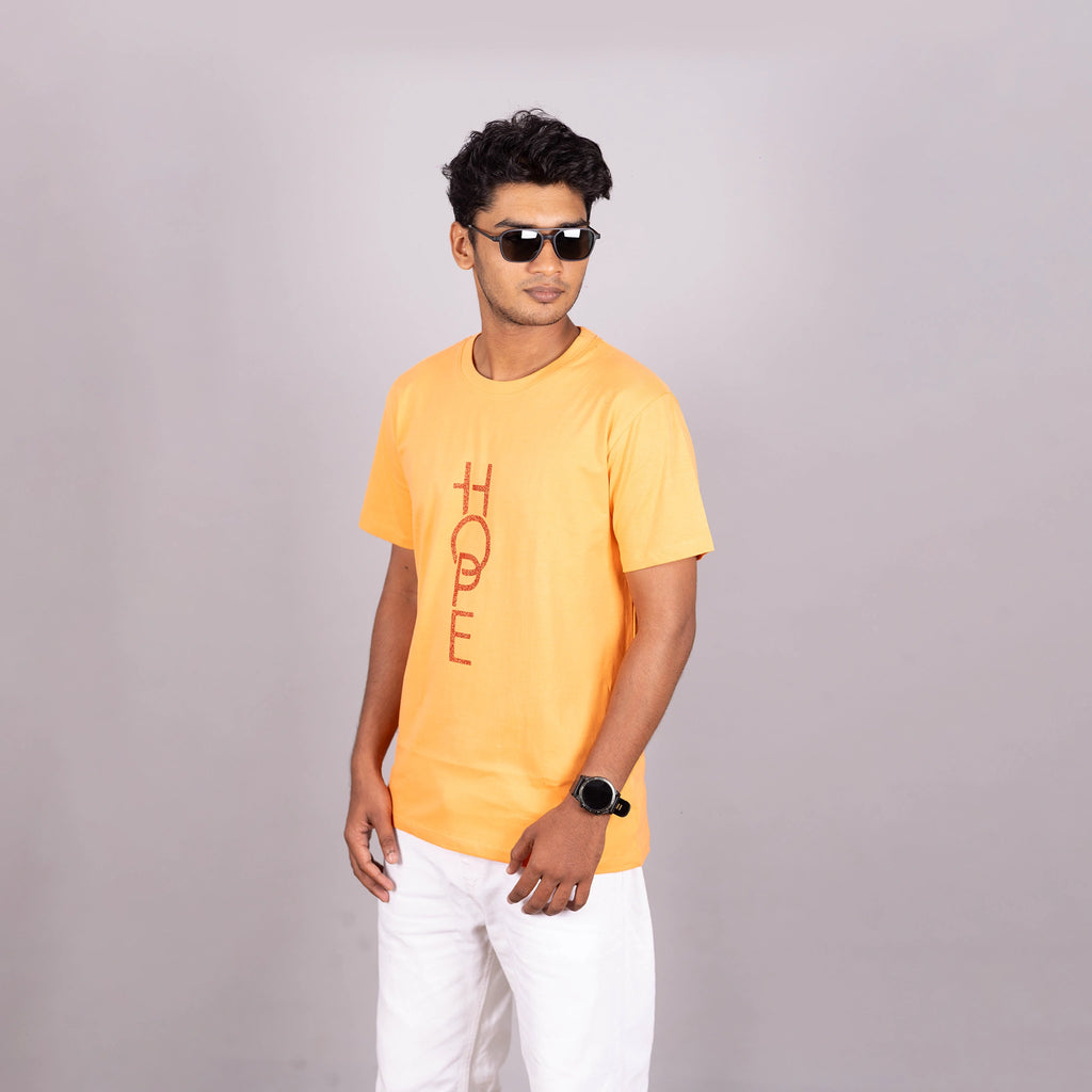 Side-angle of sunset orange “HOPE” tee showing relaxed fit and shimmer detail—mood-lifting fit