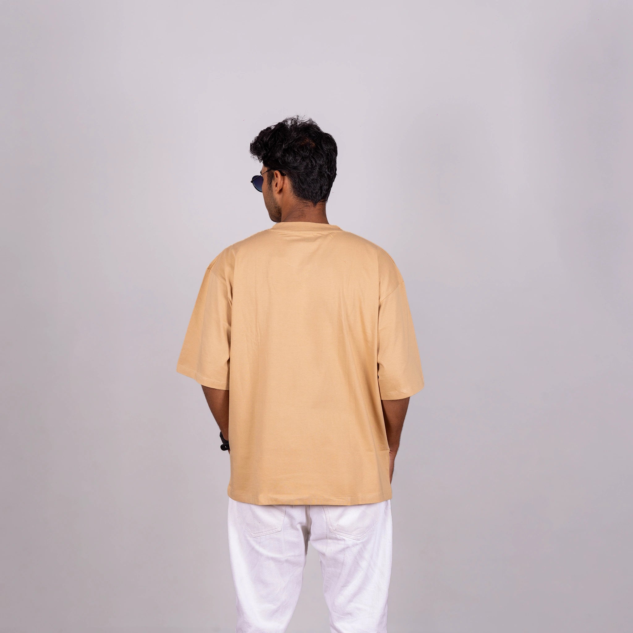 Back view of oversized tee—clean silhouette and subtle fabric drape with bold text visual balance