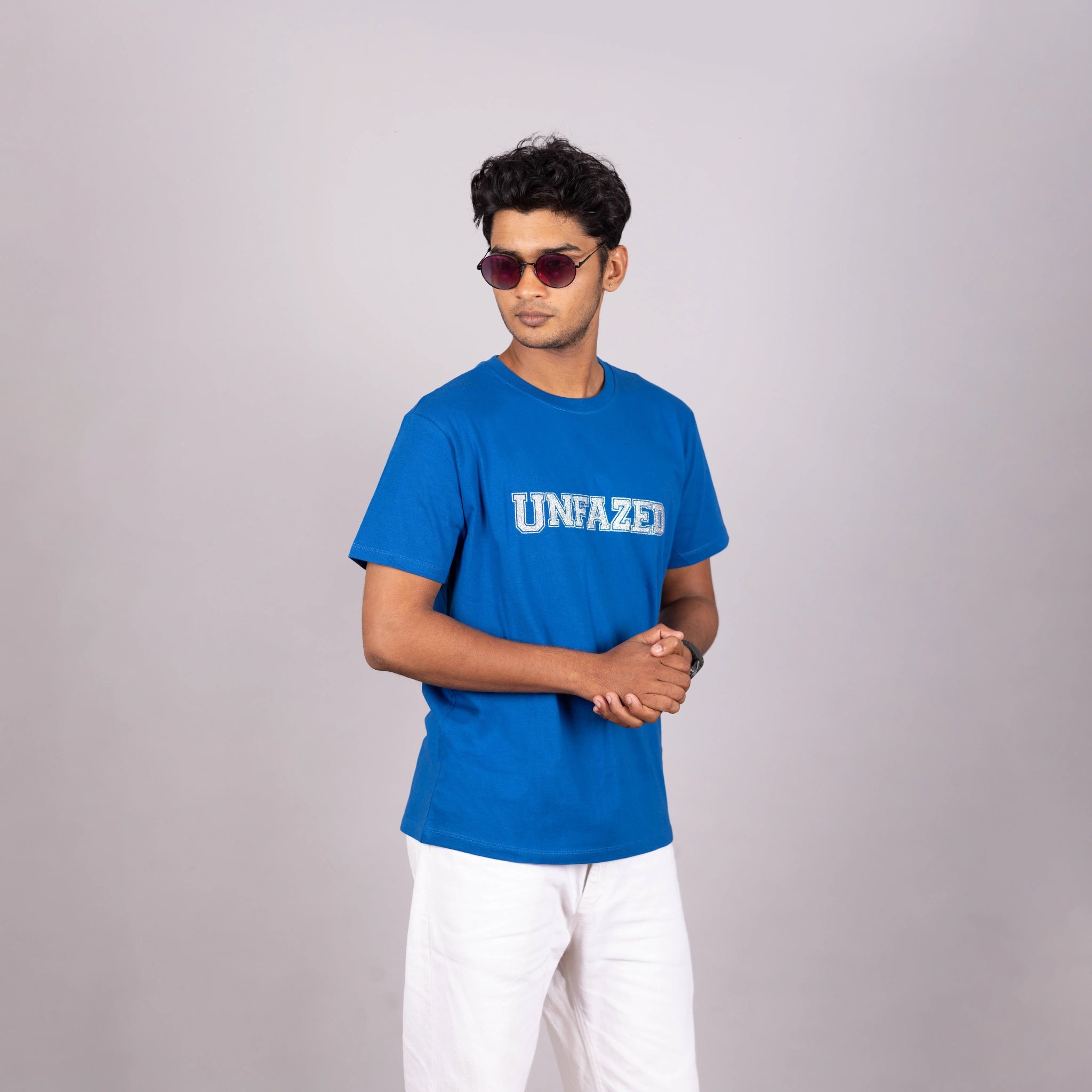 Man wearing royal blue “UNFAZED” tee with glitter print—bold, confident streetwear in India
