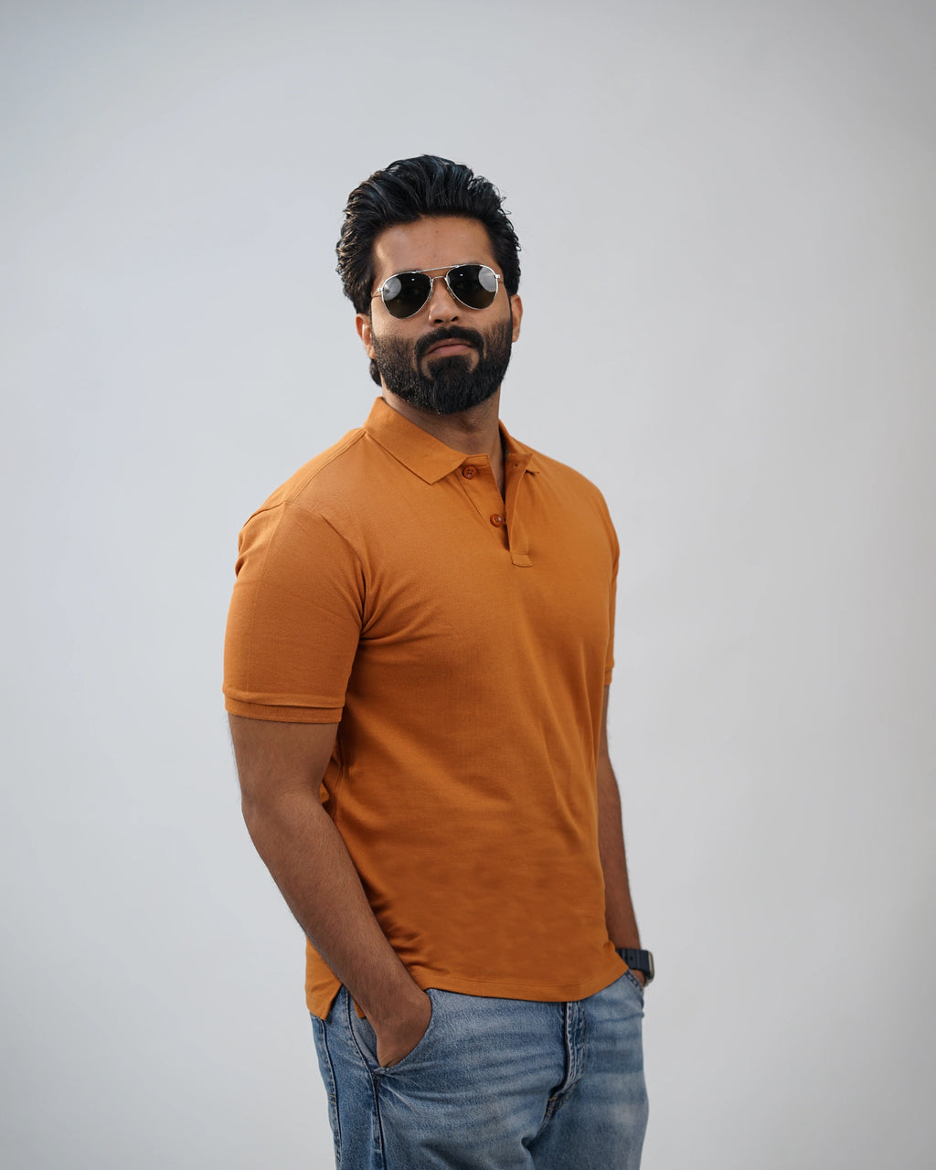 Man wearing terracotta polo tee for men in India, front view, styled with casual jeans.