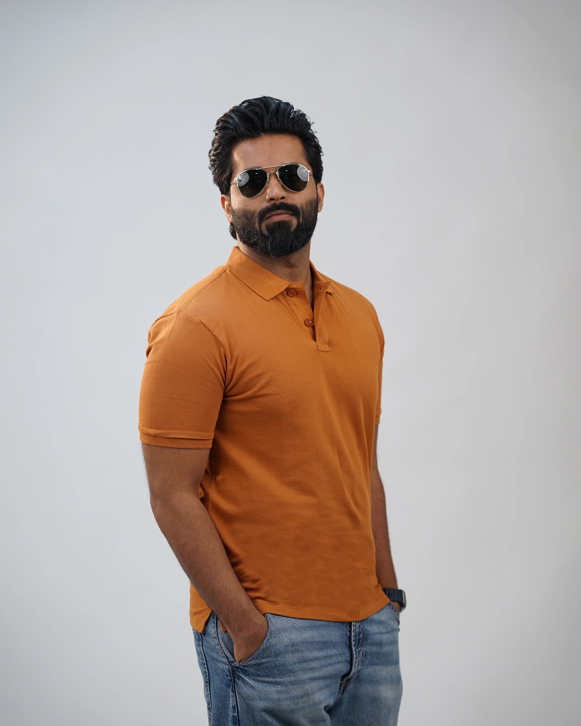Man wearing terracotta polo tee for men in India, front view, styled with casual jeans.