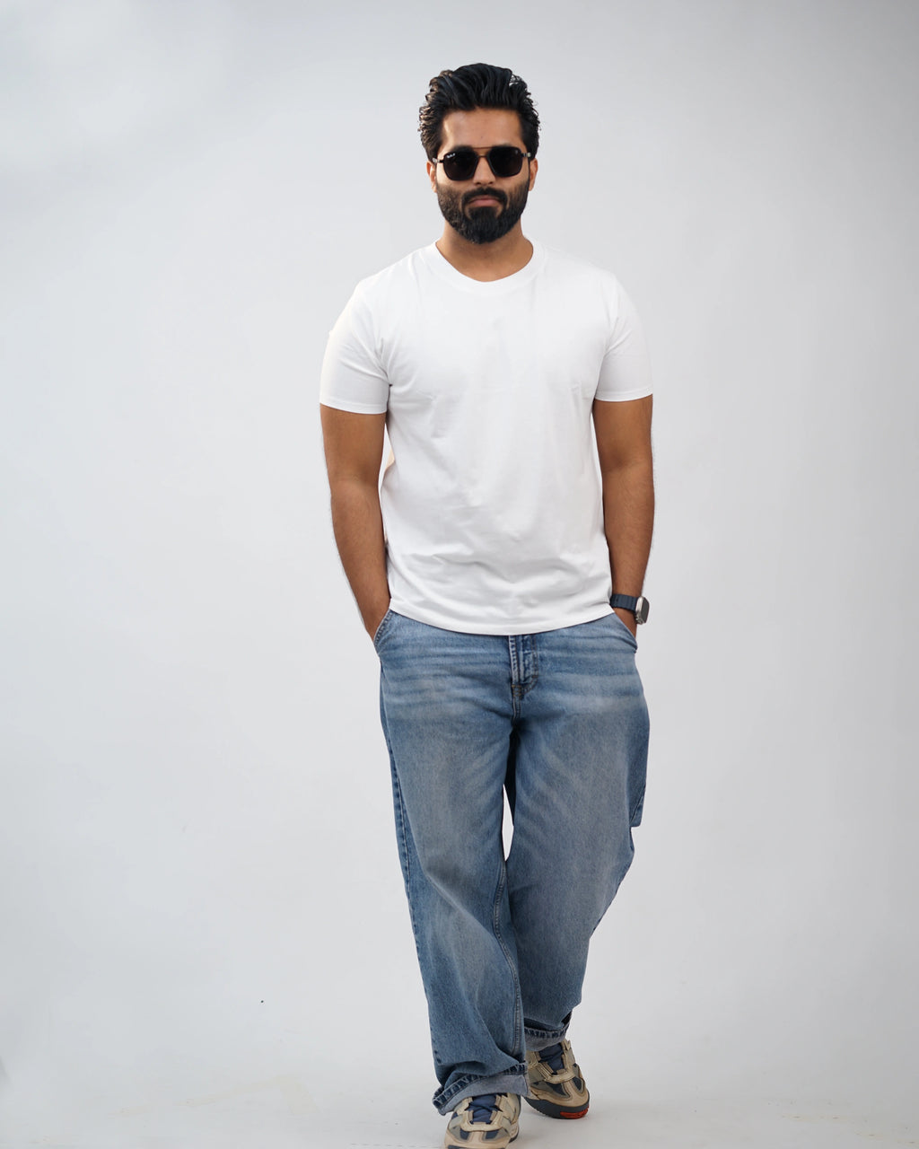 Man wearing classic white crew-neck tee for men, front view, styled with blue jeans