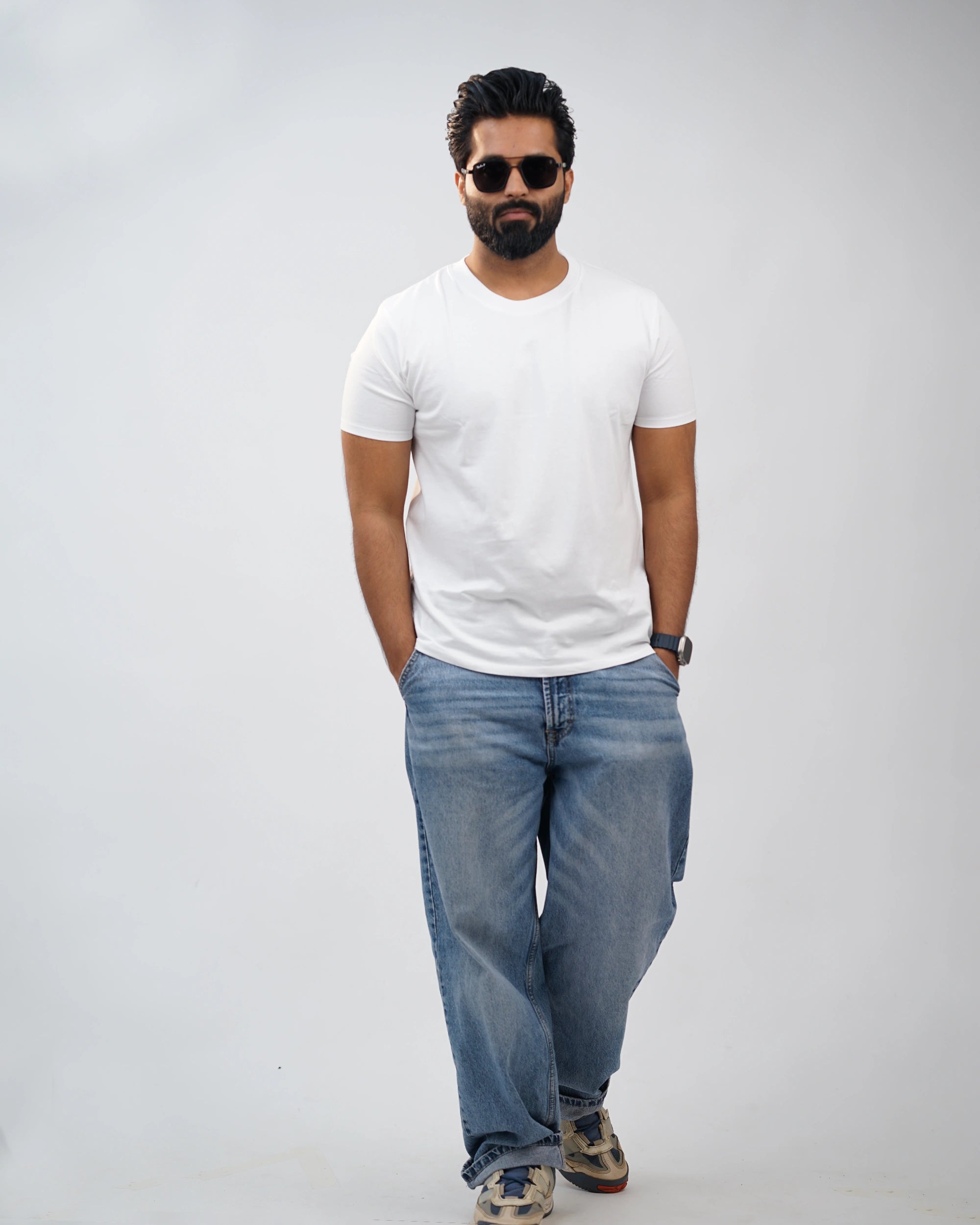 Man wearing classic white crew-neck tee for men, front view, styled with blue jeans