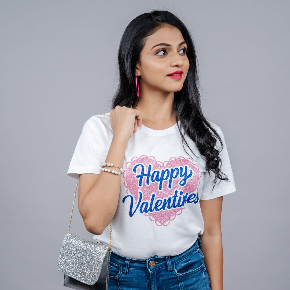Close-up of white 'Happy Valentine' tee showing glitter pink heart and blue “Happy Valentine’s” text