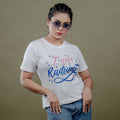 White women’s tee front close-up with glitter ‘I Am Radiant’ print in pink and blue